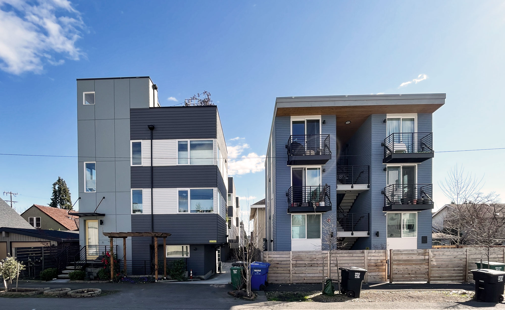 Exterior street view of blue/gray modern single family homes.