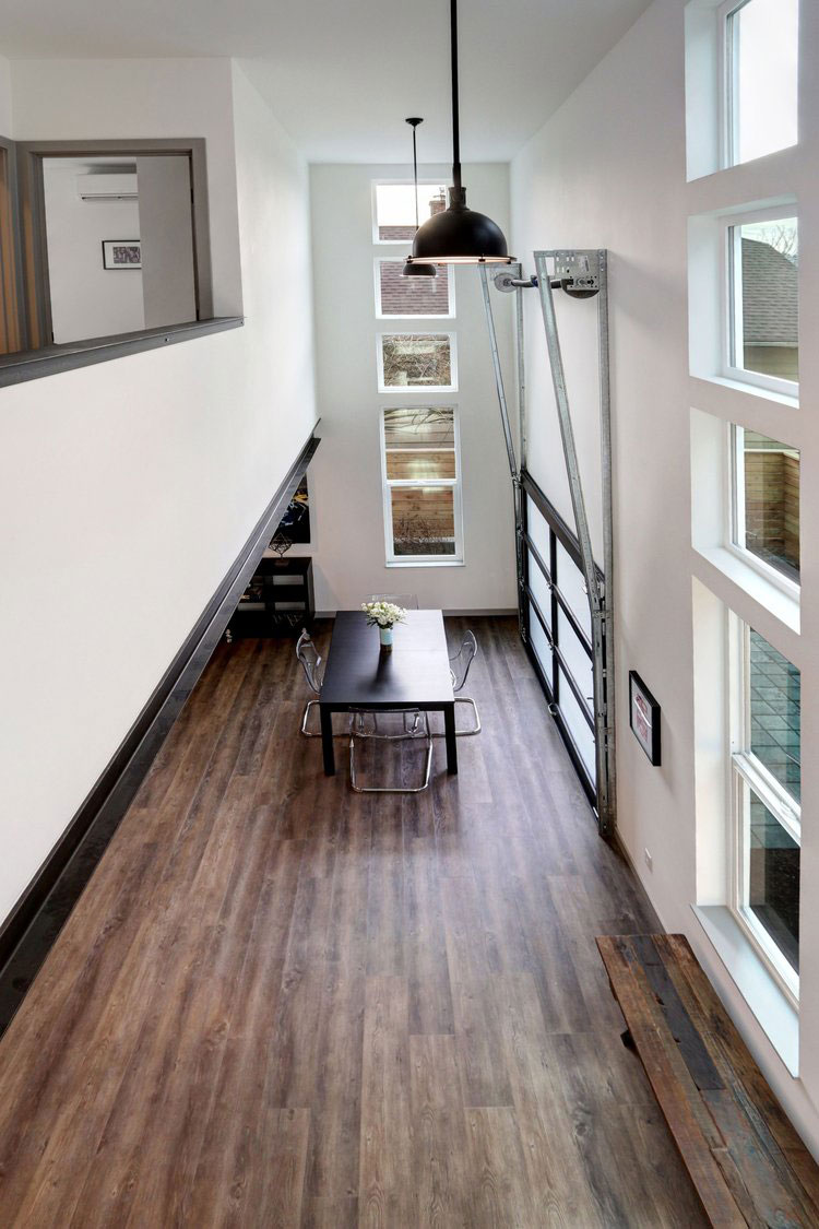 Dining room with black table, modern black hanging light fixtures, and large windows