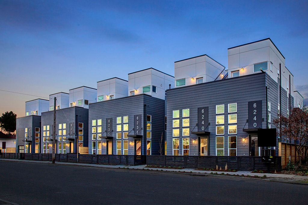 Night exterior shot of row of townhomes and single family homes