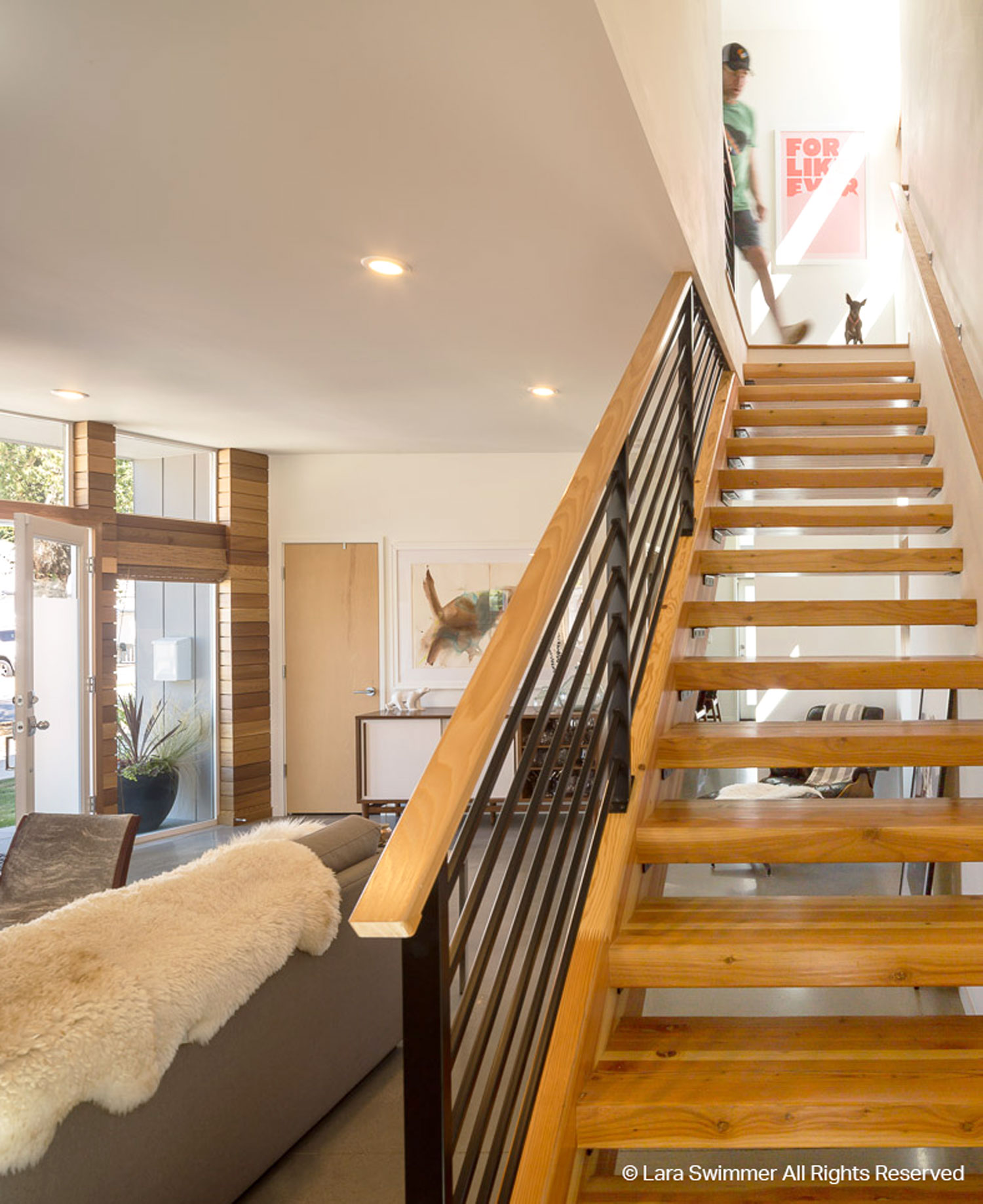 Interior stair case with medium wood and black metal, industrial details.