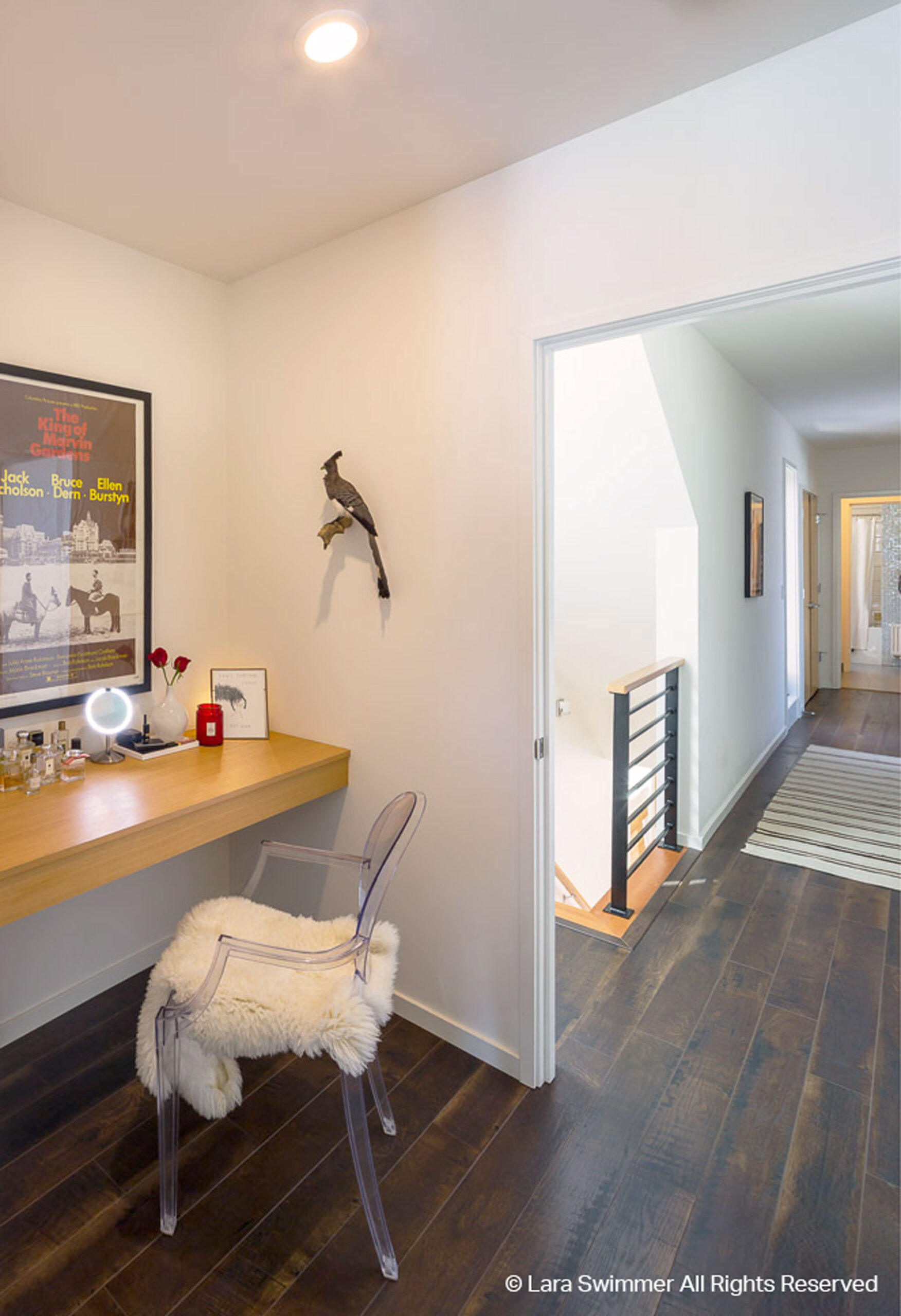 Small office space with chair and desk next to staircase.
