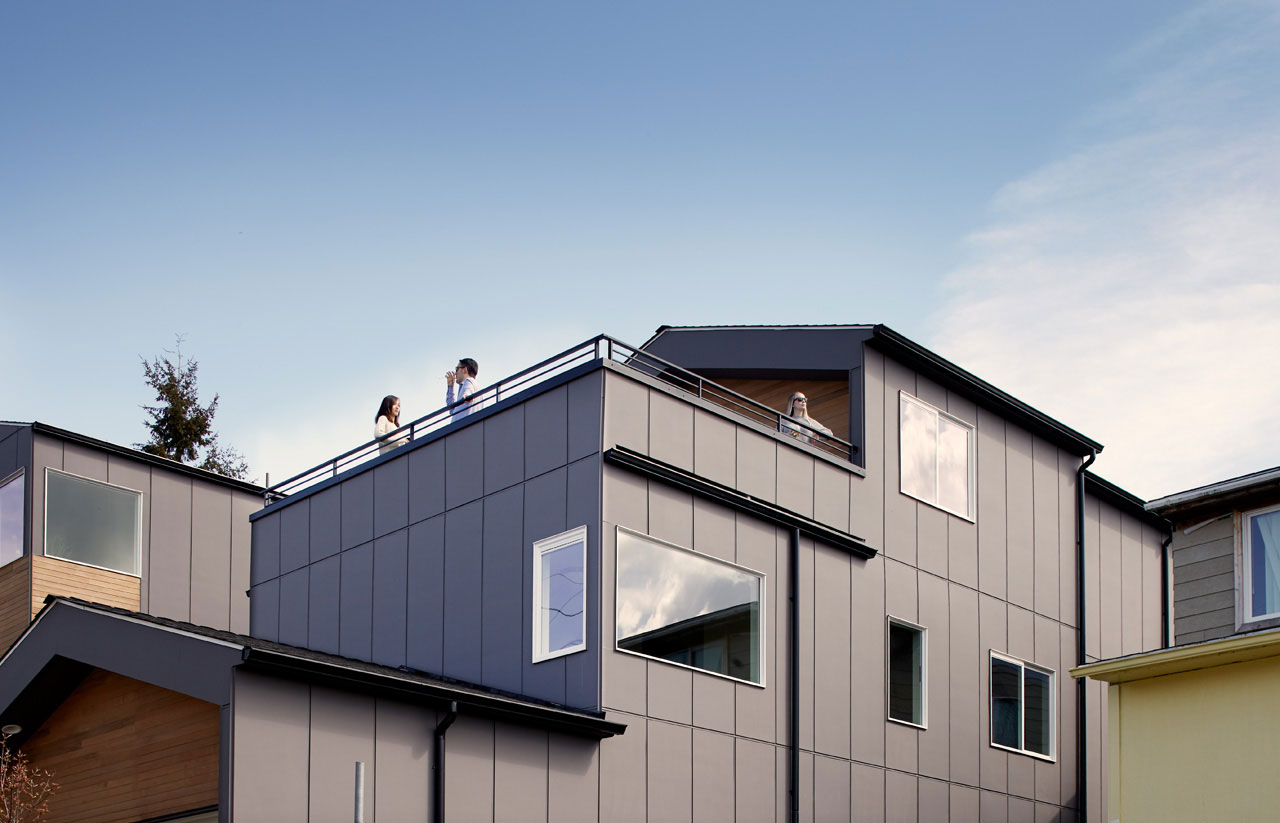 Exterior of home with several people on a rooftop deck
